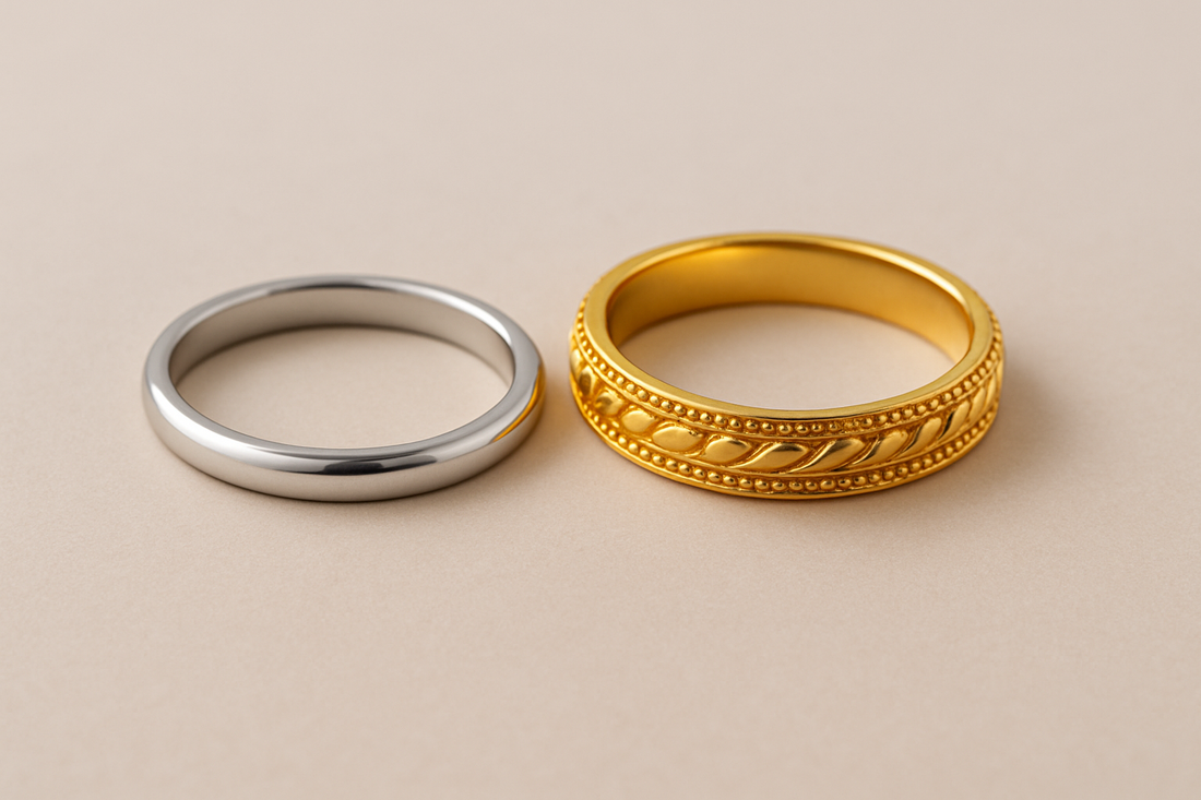 A delicate platinum ring and a high-karat gold ring side-by-side on a neutral background, symbolizing the choice between these metals for sensitive skin in fine jewellery.